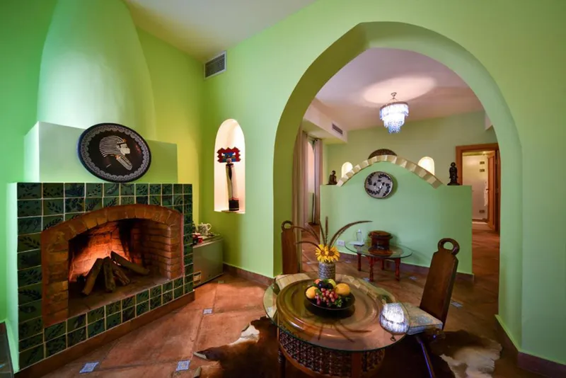 Tiled fireplace and dining table under a green arch