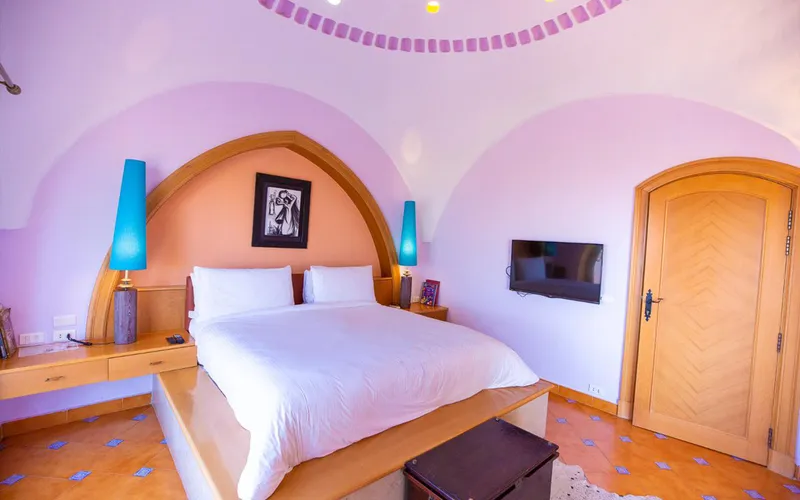 Domed bedroom in pink with turquoise lamps